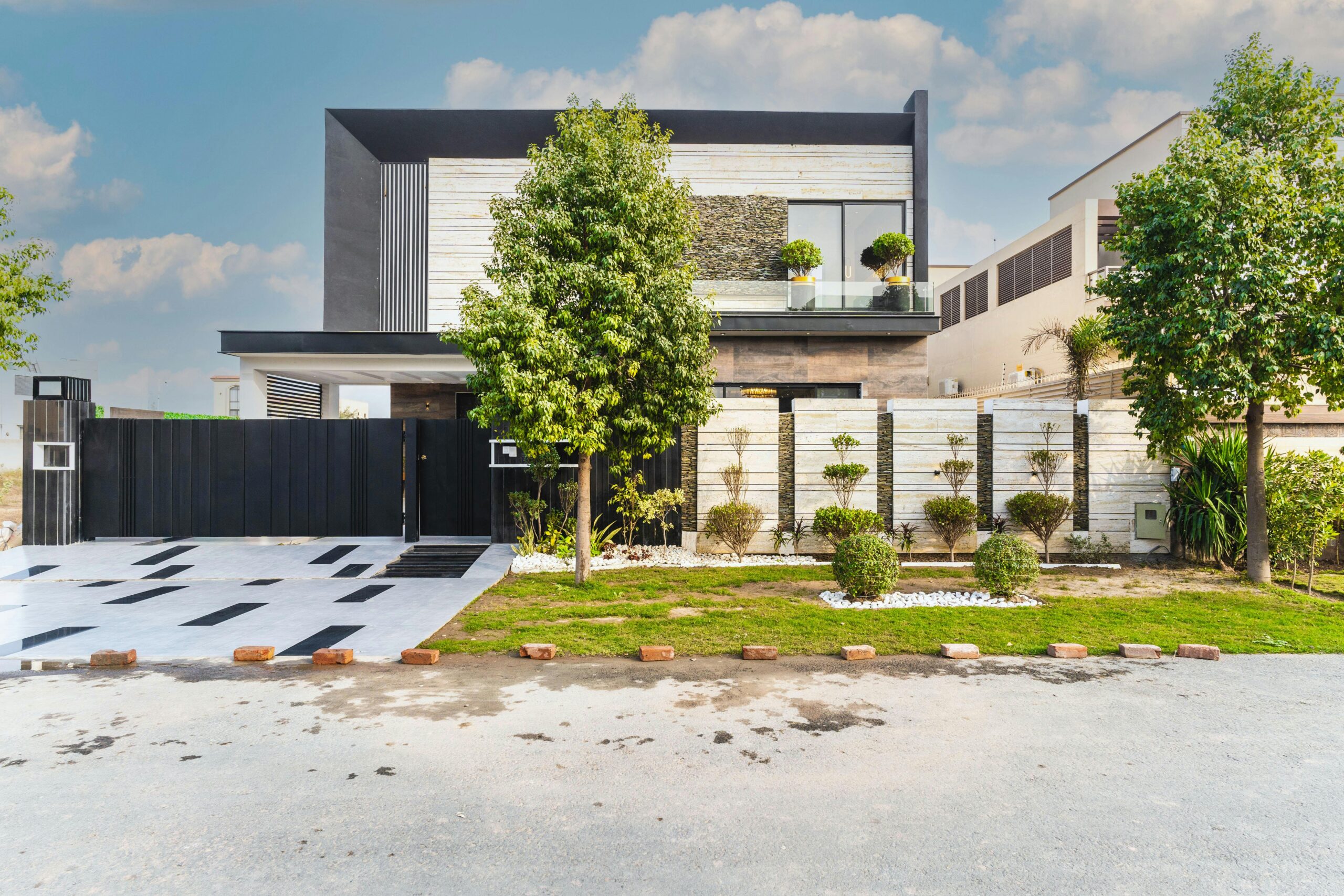 Contemporary house with sleek design in an urban street environment, featuring modern architecture and greenery.