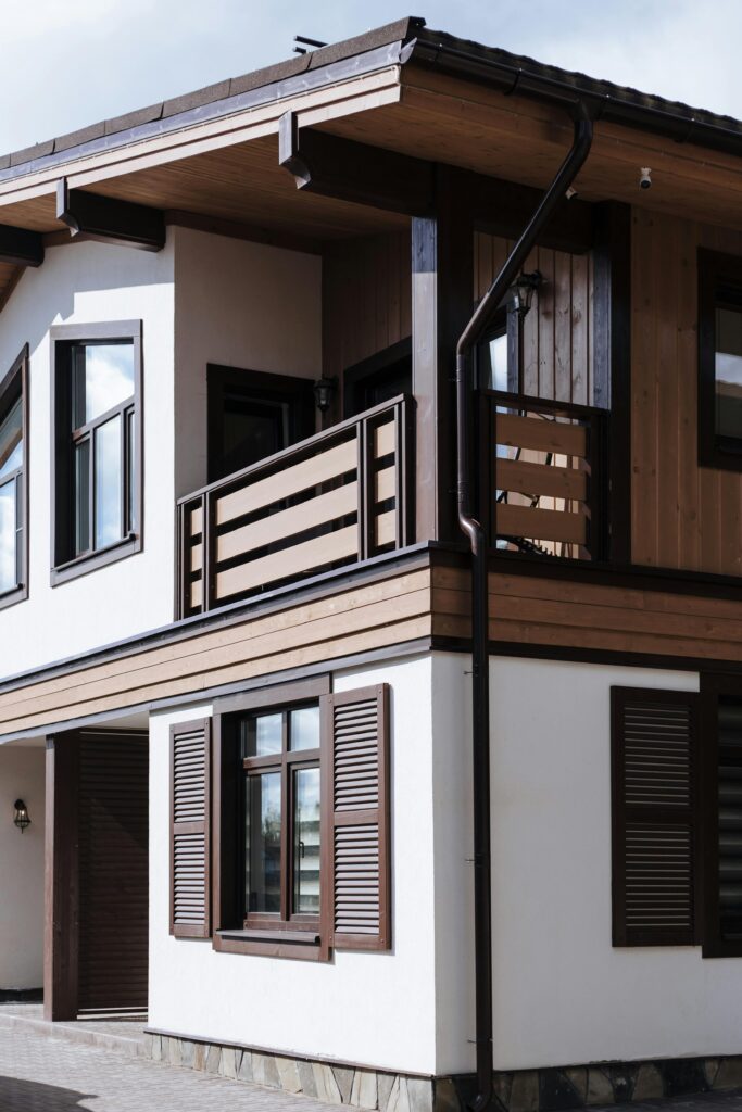 Contemporary suburban house exterior with wooden accents and shutters.